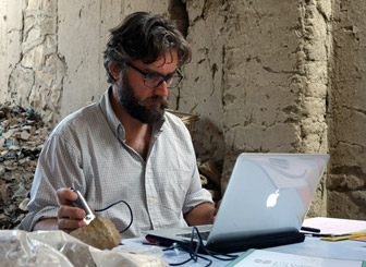 Giulio analyzes a grinding stone, from Middle Kingdom Memphis, with a USB microscope. Photo by Ana Tavares. 